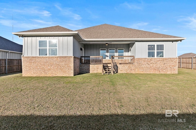 back of property featuring a fenced backyard, a lawn, board and batten siding, and ceiling fan