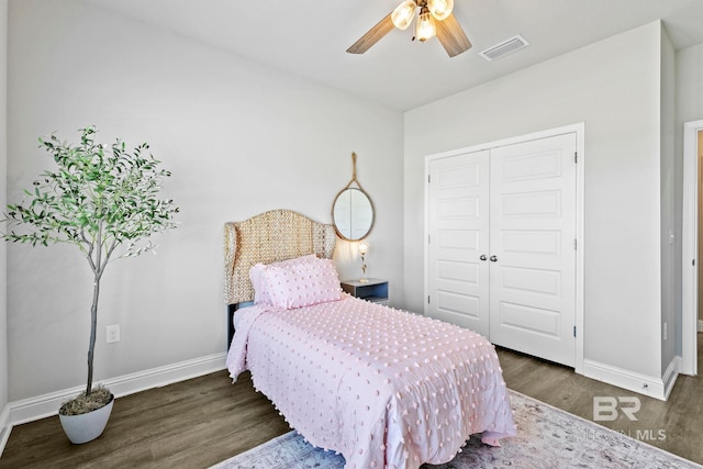 bedroom featuring visible vents, baseboards, a closet, and wood finished floors