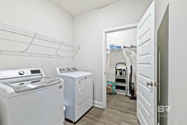 laundry area with laundry area, light wood-style flooring, and washer and clothes dryer