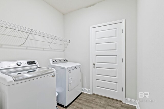 laundry room featuring laundry area, light wood-style flooring, washing machine and dryer, and baseboards