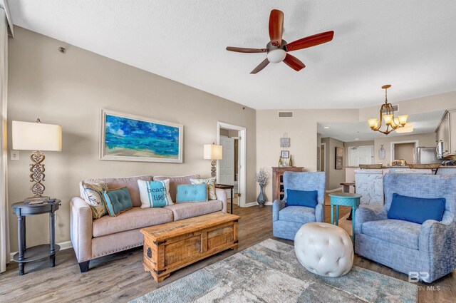527 Beach Club Trl Unit C305, Gulf Shores, AL 36542 - living room with baseboards, light wood-style flooring, visible vents, and ceiling fan with notable chandelier