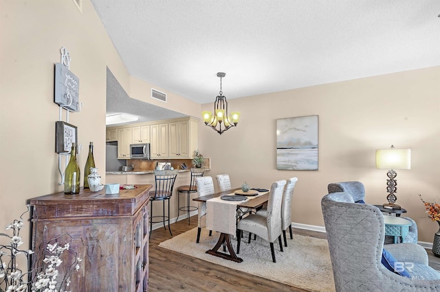 527 Beach Club Trl Unit C305, Gulf Shores, AL 36542 - dining space with baseboards, a chandelier, wood finished floors, and visible vents
