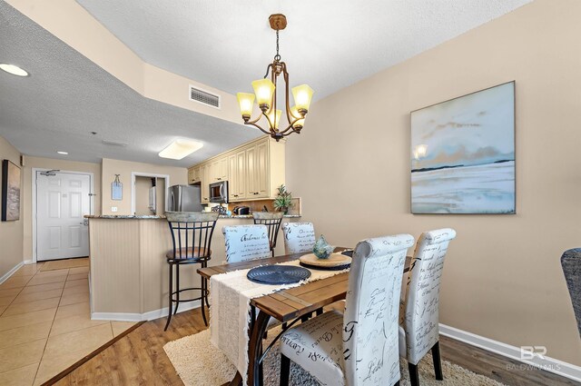 527 Beach Club Trl Unit C305, Gulf Shores, AL 36542 - dining room with baseboards, visible vents, light wood-style floors, and a notable chandelier