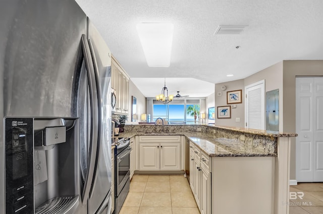527 Beach Club Trl Unit C305, Gulf Shores, AL 36542 - kitchen featuring a peninsula, a sink, a chandelier, appliances with stainless steel finishes, and light tile patterned floors