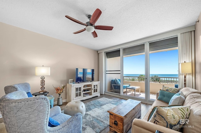 527 Beach Club Trl Unit C305, Gulf Shores, AL 36542 - living room with baseboards, a ceiling fan, wood finished floors, and a textured ceiling