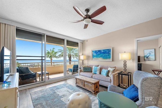 527 Beach Club Trl Unit C305, Gulf Shores, AL 36542 - living room featuring a ceiling fan, wood finished floors, a textured ceiling, and a water view