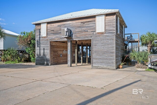 316 Quivira St, Dauphin Island, AL 36528 - back of house with a carport, a standing seam roof, metal roof, and driveway