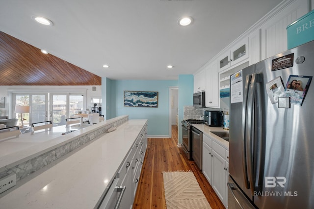 316 Quivira St, Dauphin Island, AL 36528 - kitchen featuring dark wood finished floors, white cabinets, glass insert cabinets, and stainless steel appliances