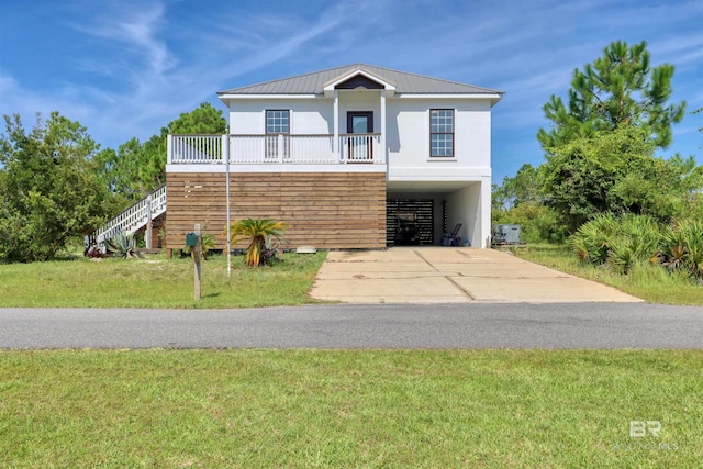 view of front of home featuring concrete driveway, a carport, metal roof, stucco siding, and stairs
