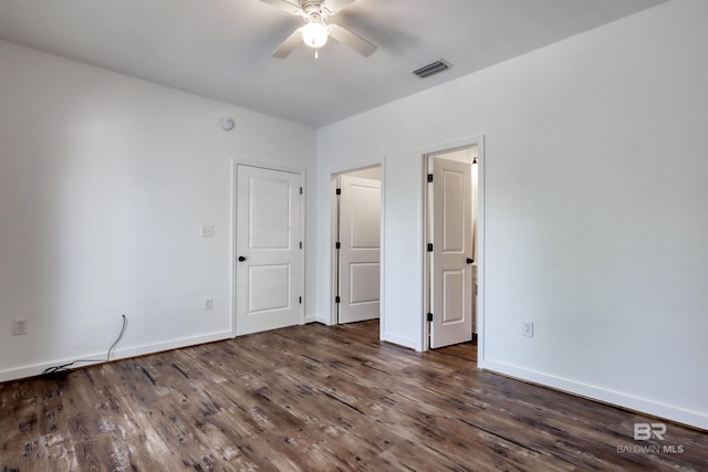 unfurnished bedroom featuring dark wood-style floors, baseboards, and visible vents