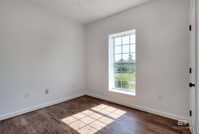 empty room featuring wood finished floors and baseboards