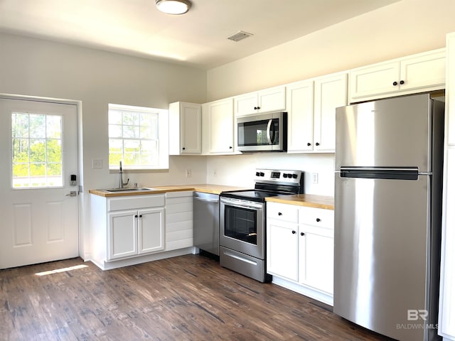 kitchen with white cabinetry, a sink, dark wood-type flooring, and appliances with stainless steel finishes