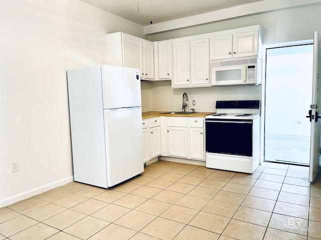 kitchen featuring white cabinets, white appliances, a sink, and light tile patterned floors