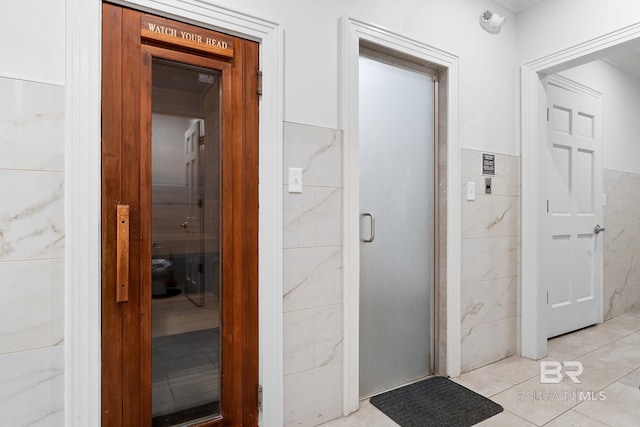 375 Beach Club Dr Unit 1801, Gulf Shores, AL 36542 - hallway featuring tile walls, a sauna, light tile patterned floors, and a wainscoted wall