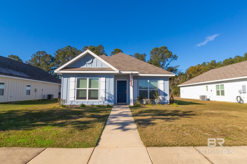 bungalow-style house with a front lawn and central air condition unit