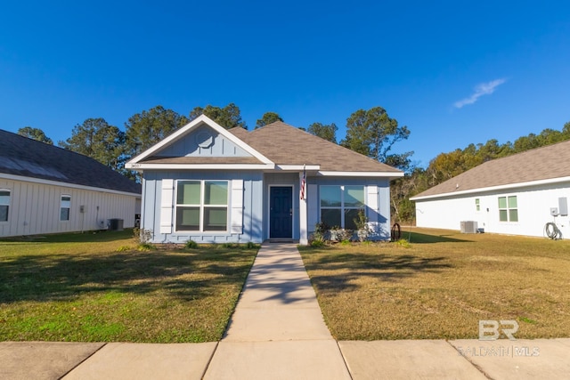 bungalow-style house with a front lawn and central air condition unit