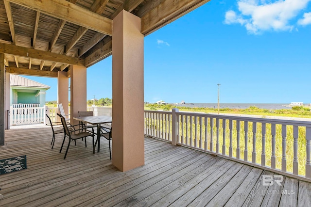 wooden deck with a water view and a view of the beach