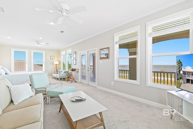 carpeted living room with french doors, ornamental molding, and ceiling fan