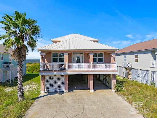 raised beach house featuring a carport and a front yard