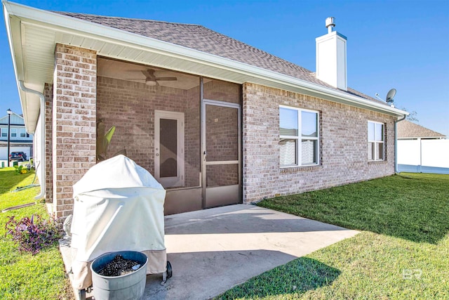 rear view of house with a yard, a patio, and a sunroom