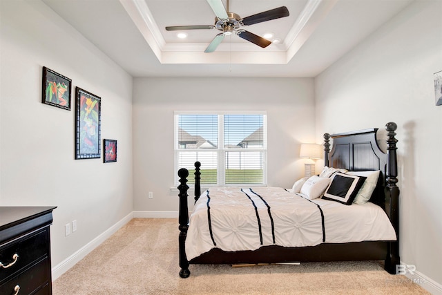 bedroom with a tray ceiling, ceiling fan, light carpet, and ornamental molding