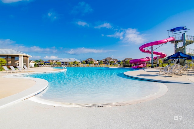 view of swimming pool with a patio area and a water slide