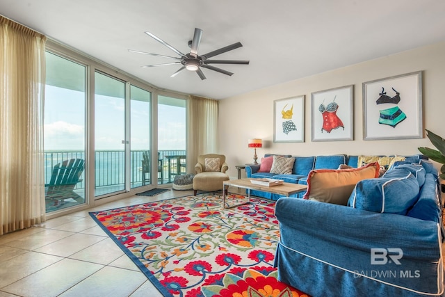 tiled living room featuring expansive windows and ceiling fan