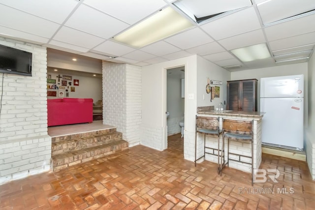 kitchen featuring a paneled ceiling, sink, and white refrigerator