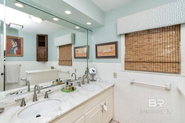 bathroom with vanity and tile walls