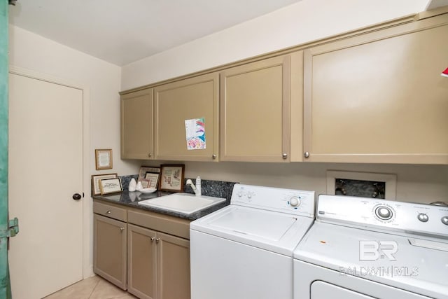 clothes washing area featuring cabinets, light tile patterned floors, sink, and washing machine and dryer