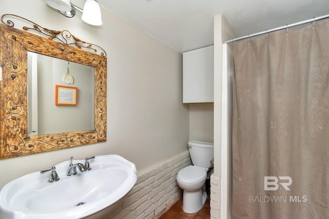 bathroom featuring a shower with curtain, sink, and toilet