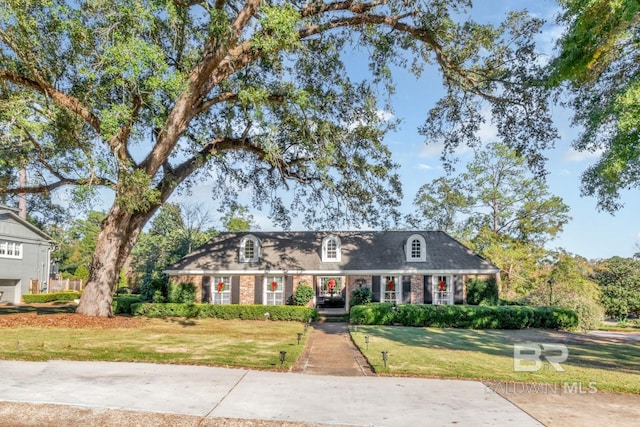 cape cod home with a front yard