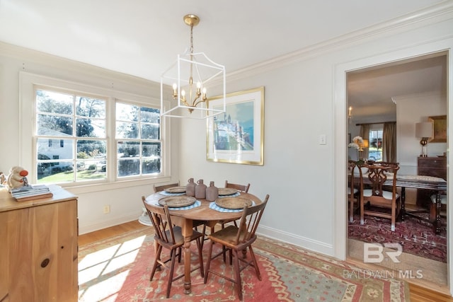 dining area with ornamental molding, light hardwood / wood-style floors, and an inviting chandelier