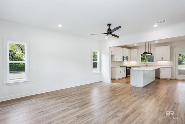 5099 Leeward Dr, Pensacola, FL 32507 - kitchen with appliances with stainless steel finishes, a kitchen island, plenty of natural light, light countertops, and crown molding