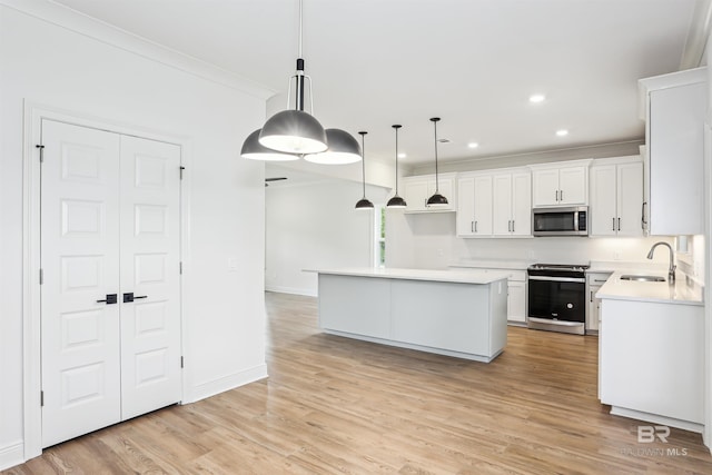 5099 Leeward Dr, Pensacola, FL 32507 - kitchen with stainless steel microwave, stove, a sink, a center island, and white cabinets