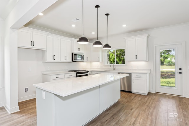 5099 Leeward Dr, Pensacola, FL 32507 - kitchen with stainless steel appliances, a sink, white cabinets, a center island, and light countertops