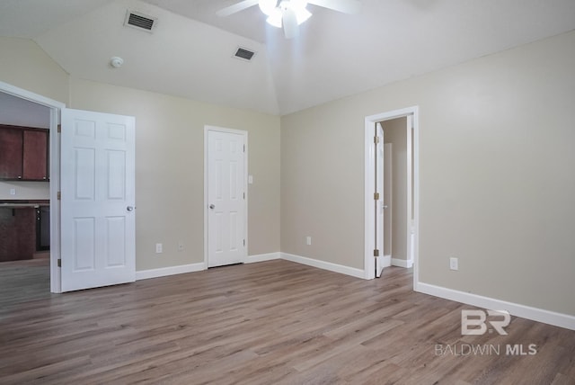 unfurnished bedroom with light hardwood / wood-style flooring, vaulted ceiling, and ceiling fan