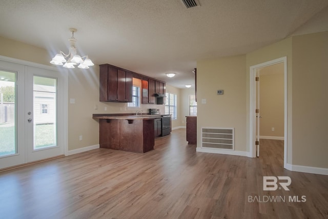 kitchen with pendant lighting, a breakfast bar, electric range, kitchen peninsula, and light wood-type flooring