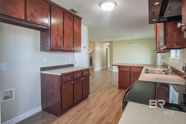 kitchen featuring hanging light fixtures, sink, electric range, and light hardwood / wood-style floors