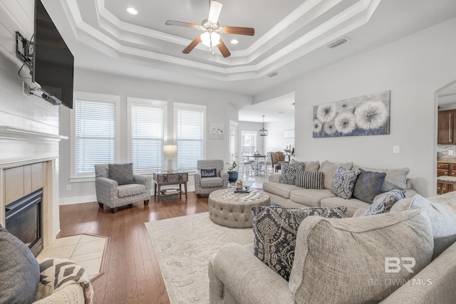 living room with hardwood / wood-style floors, plenty of natural light, and a raised ceiling