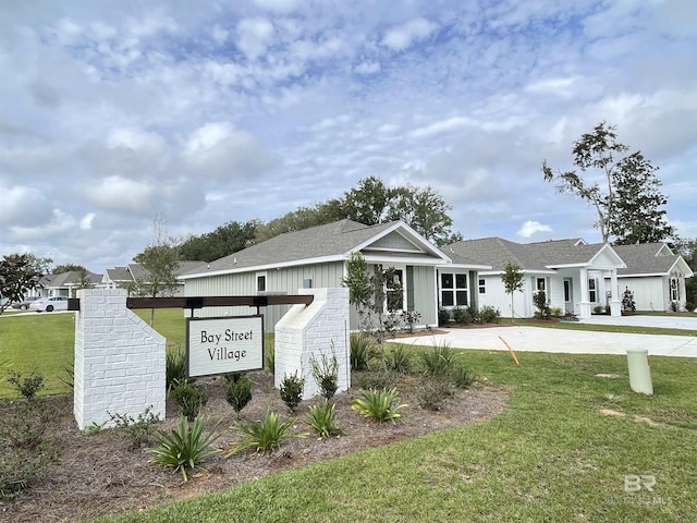 view of front of property with driveway, a shingled roof, and a front lawn