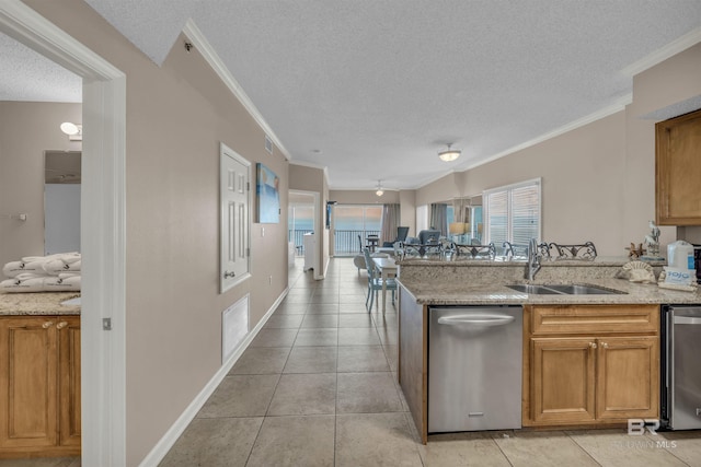 kitchen featuring open floor plan, ornamental molding, brown cabinets, a textured ceiling, and a sink