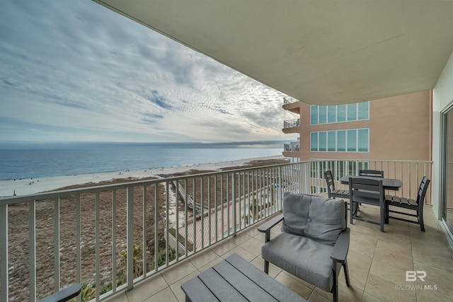 balcony featuring a view of the beach and a water view