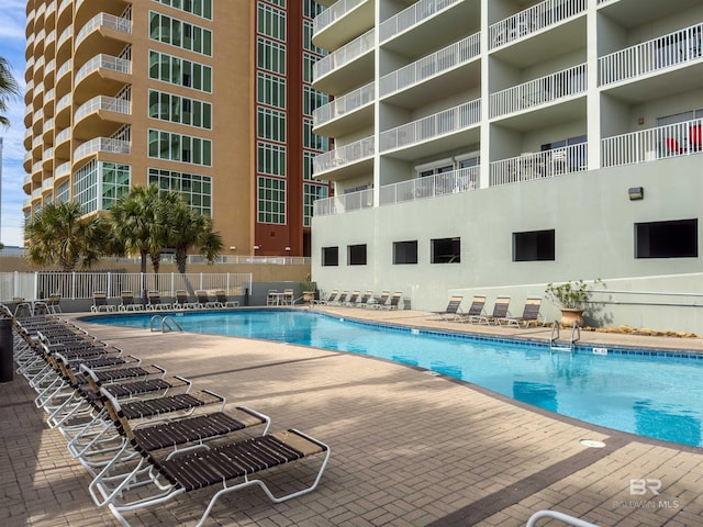 pool with a patio area and fence