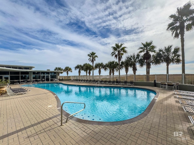 community pool featuring a patio and fence