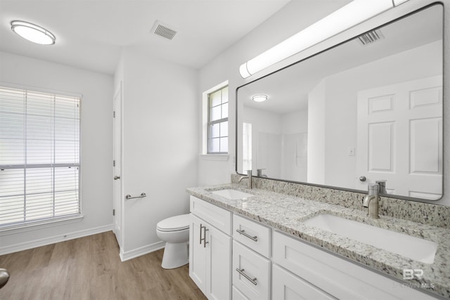 16063 Mansion St, Foley, AL 36535 - bathroom with double vanity, toilet, wood finished floors, baseboards, and a shower