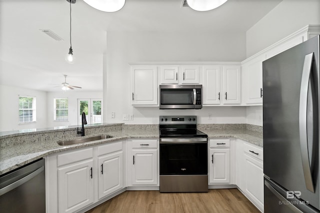16063 Mansion St, Foley, AL 36535 - kitchen featuring appliances with stainless steel finishes, a sink, ceiling fan, white cabinetry, and light wood-style flooring