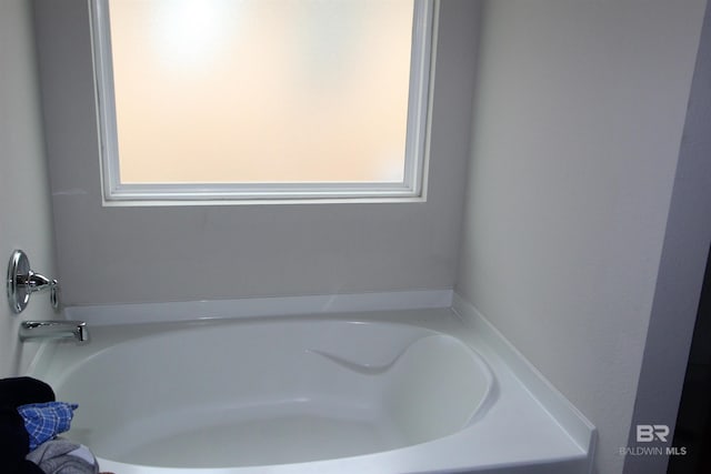 bathroom featuring a tub and a wealth of natural light