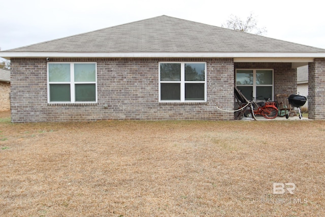 back of property featuring a lawn