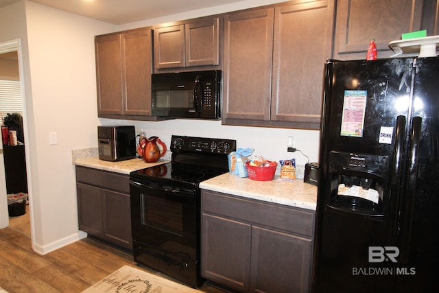 kitchen with dark brown cabinets, light hardwood / wood-style flooring, and black appliances